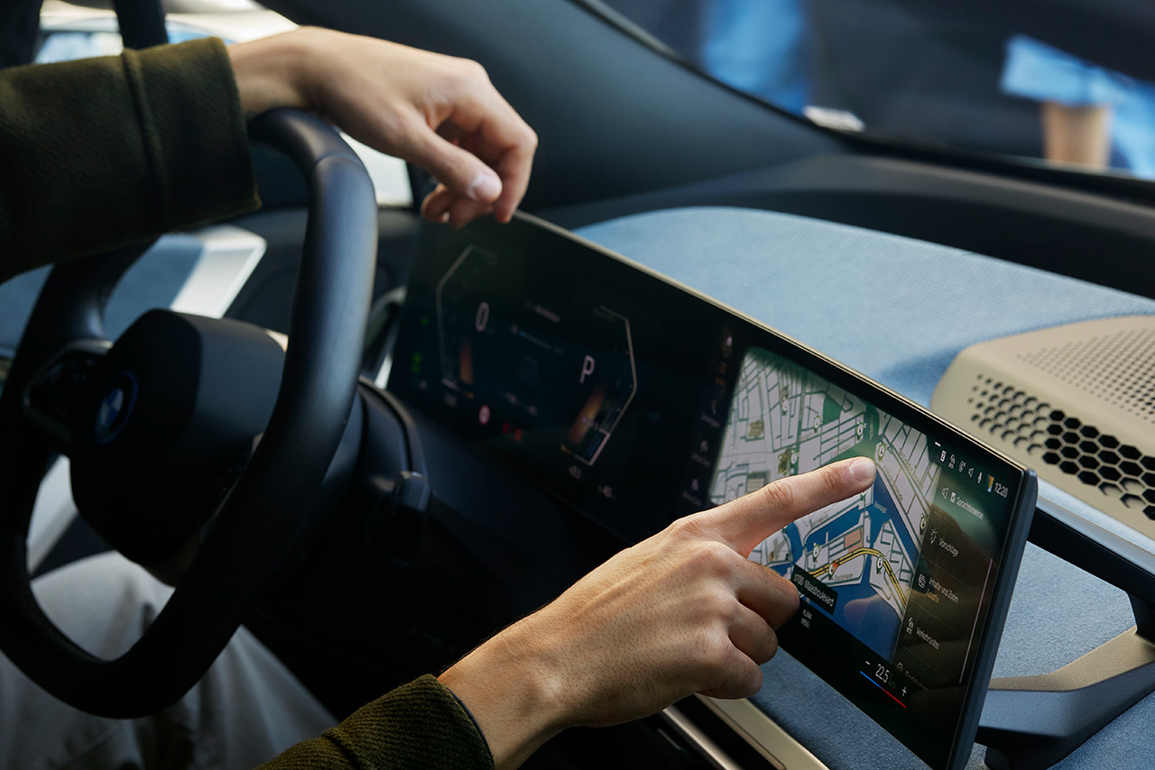 Someone is sitting in a car and using the In-Car Display
