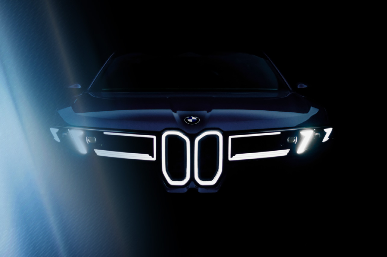 Front view of a BMW iX3 in the dark with flickering light from the left side.
