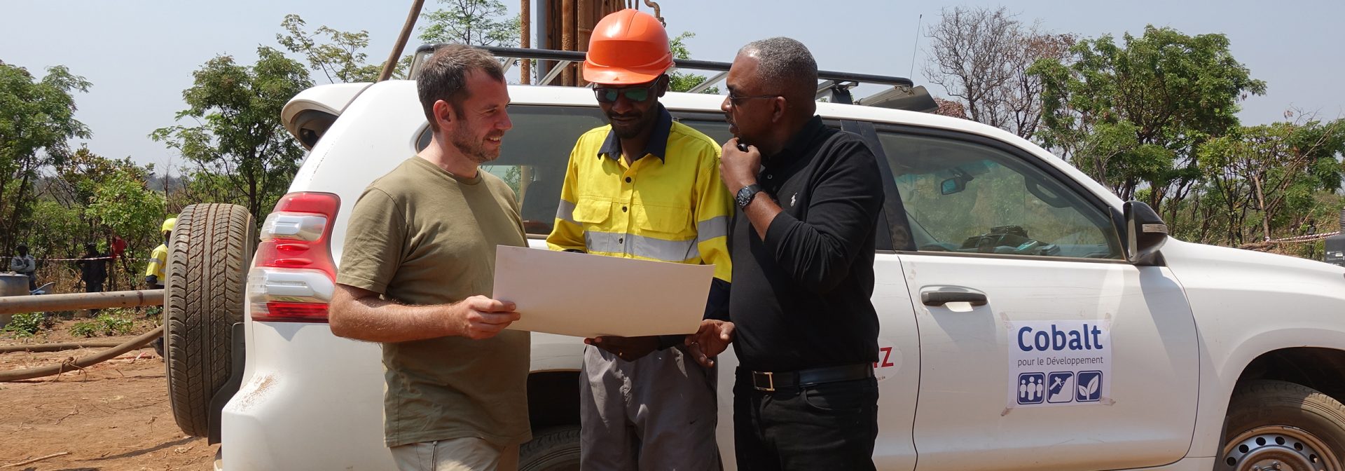 Partners of the "Cobalt for development project" stand in front of a drilling crane