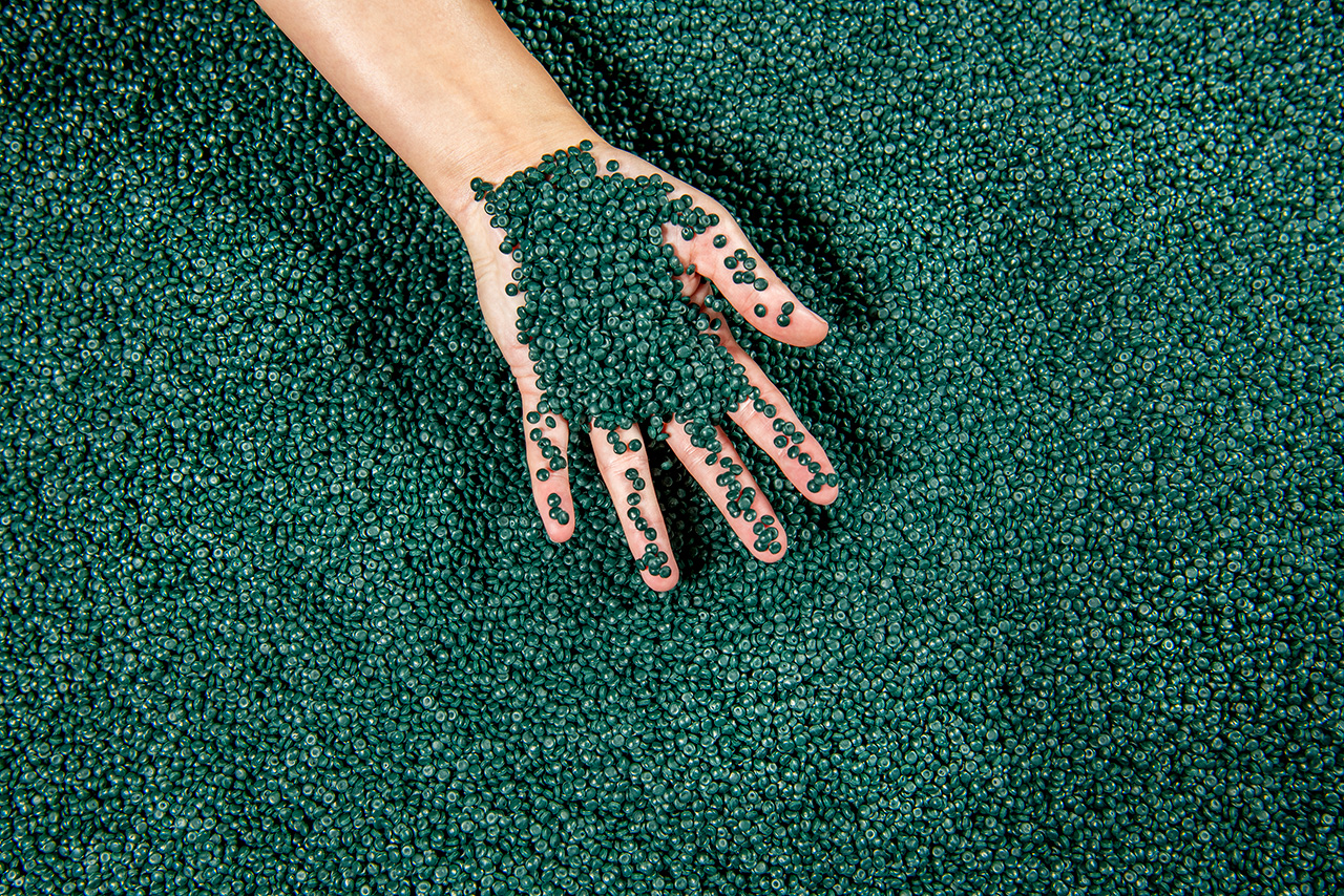 A hand grips recyclate