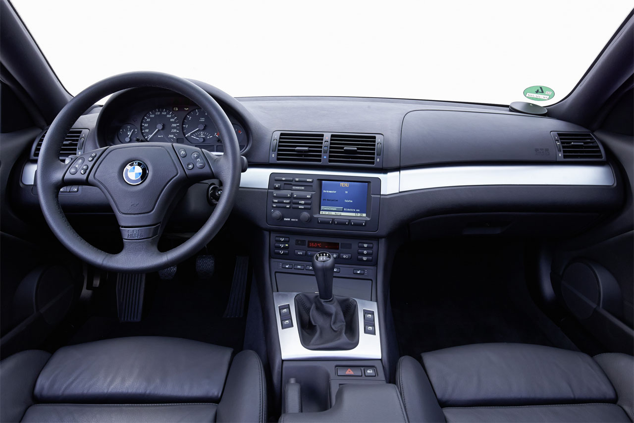 Driver-focused: A detailed view of the cockpit, centre console with infotainment unit, and dashboard in a manual E46 Coupe.