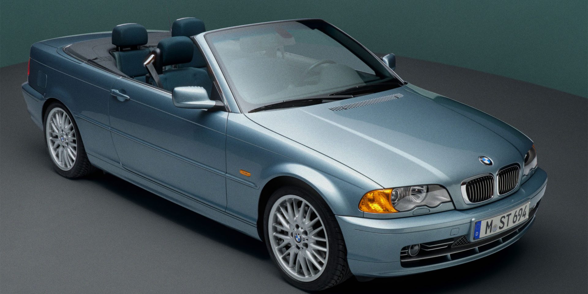 An open-topped BMW E46 Convertible in light blue, seen diagonally from above to show the front, bonnet and right-hand side.
