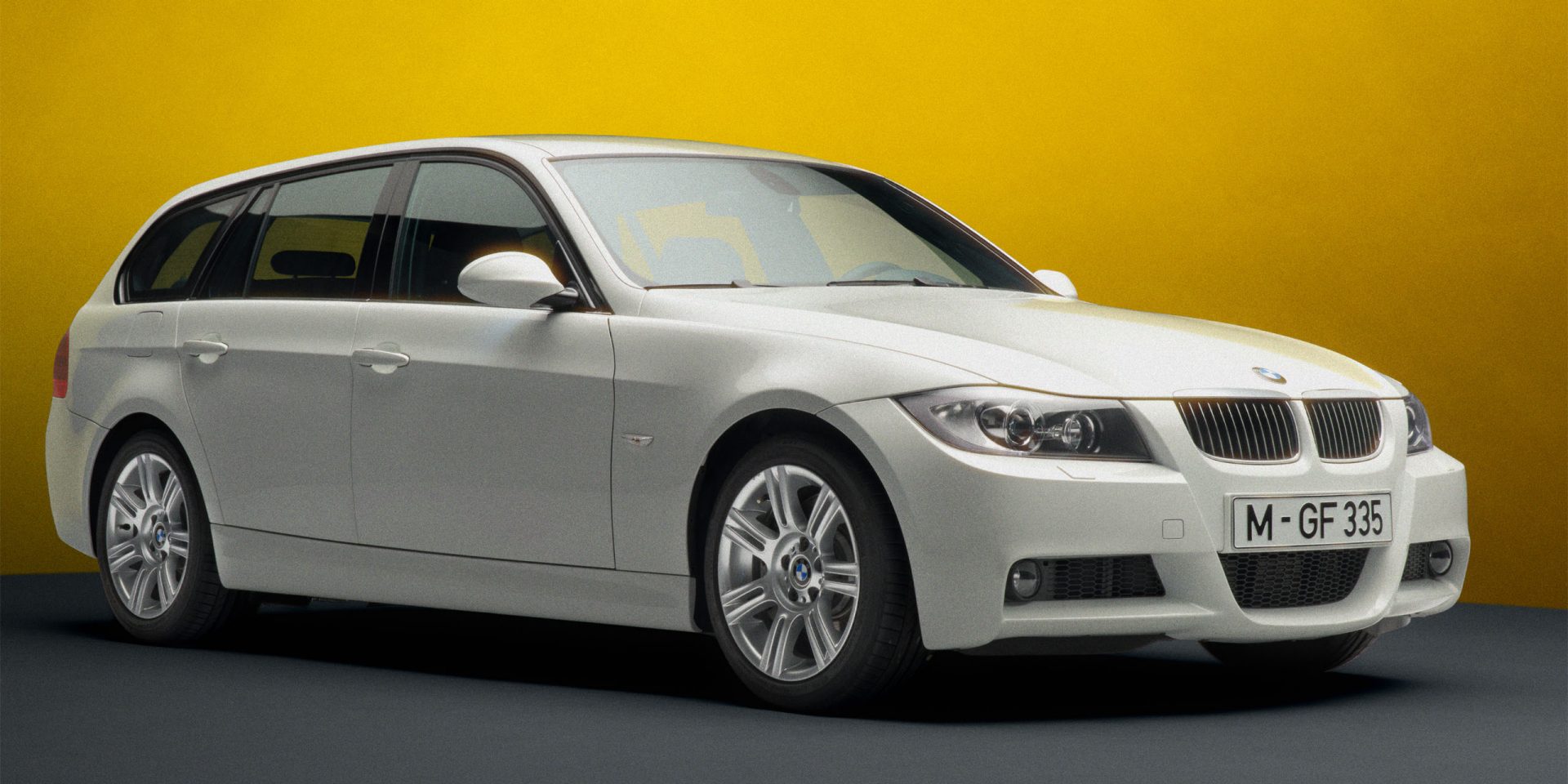 A BMW E91 Touring in white, seen from the front right with a focus on the right-hand side and the front.