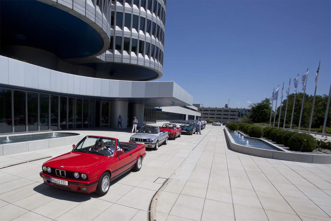 Classics before an iconic backdrop: A row of open-topped BMW E30 Convertibles pictured at a fan convention in Munich.