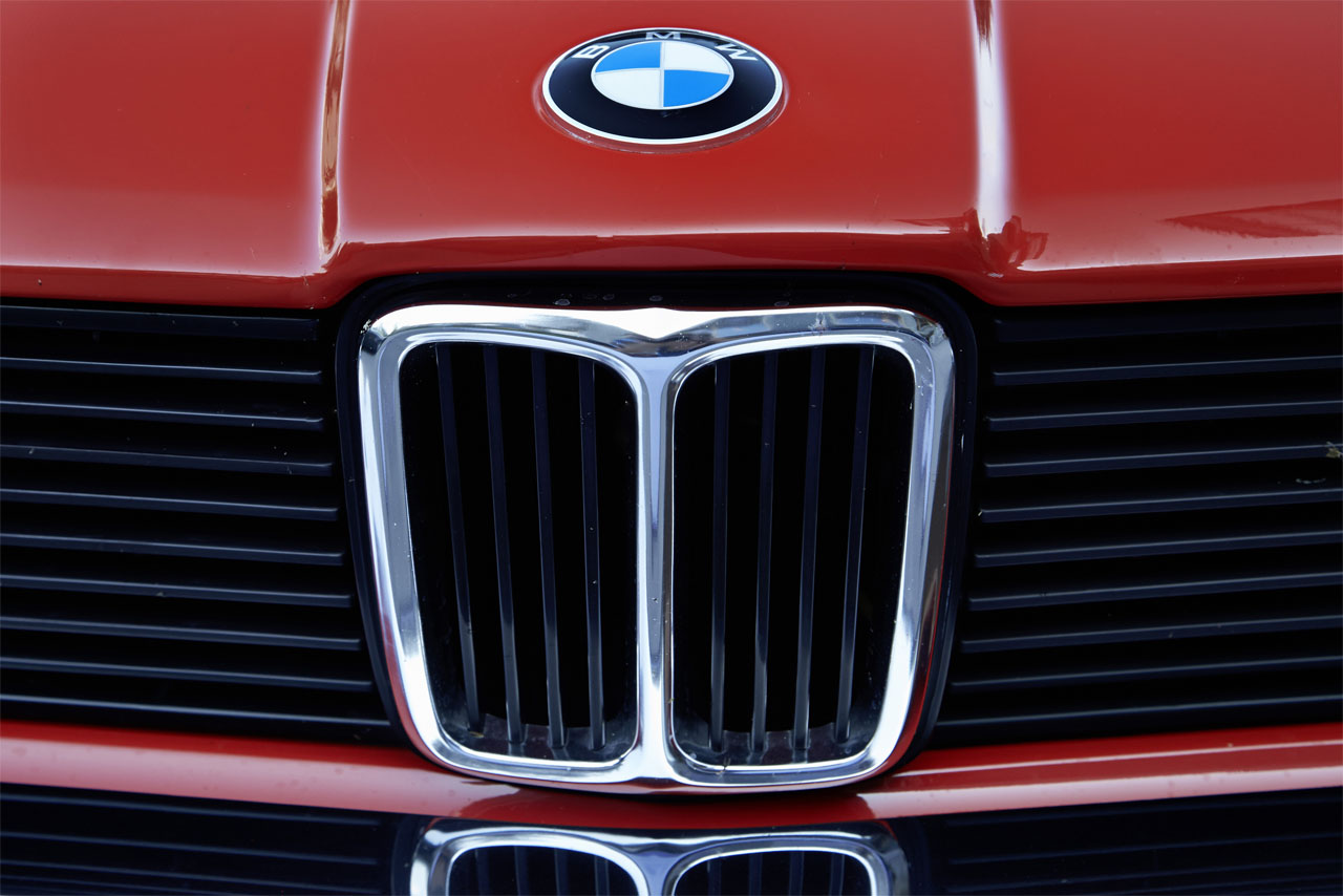 The classic kidney grille with chrome surround: A close-up of the iconic BMW kidney grille on a red E21.