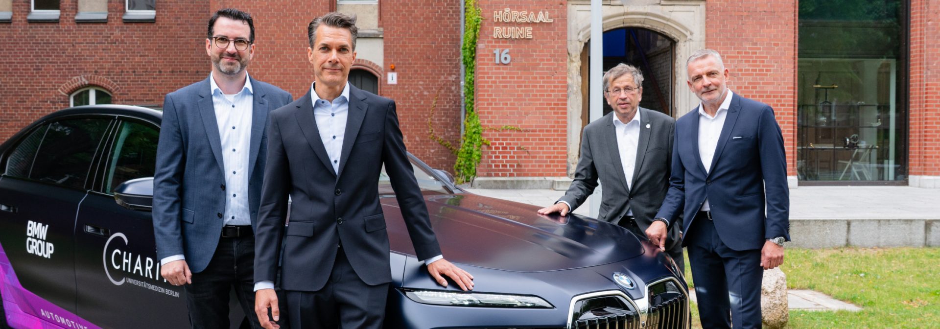 Professor Alexander Meyer, Dr Matthias Franz, Professor Heyo K. Kroemer and Dr Rudolf Bencker beside a BMW 750e xDrive plug-in hybrid research vehicle.