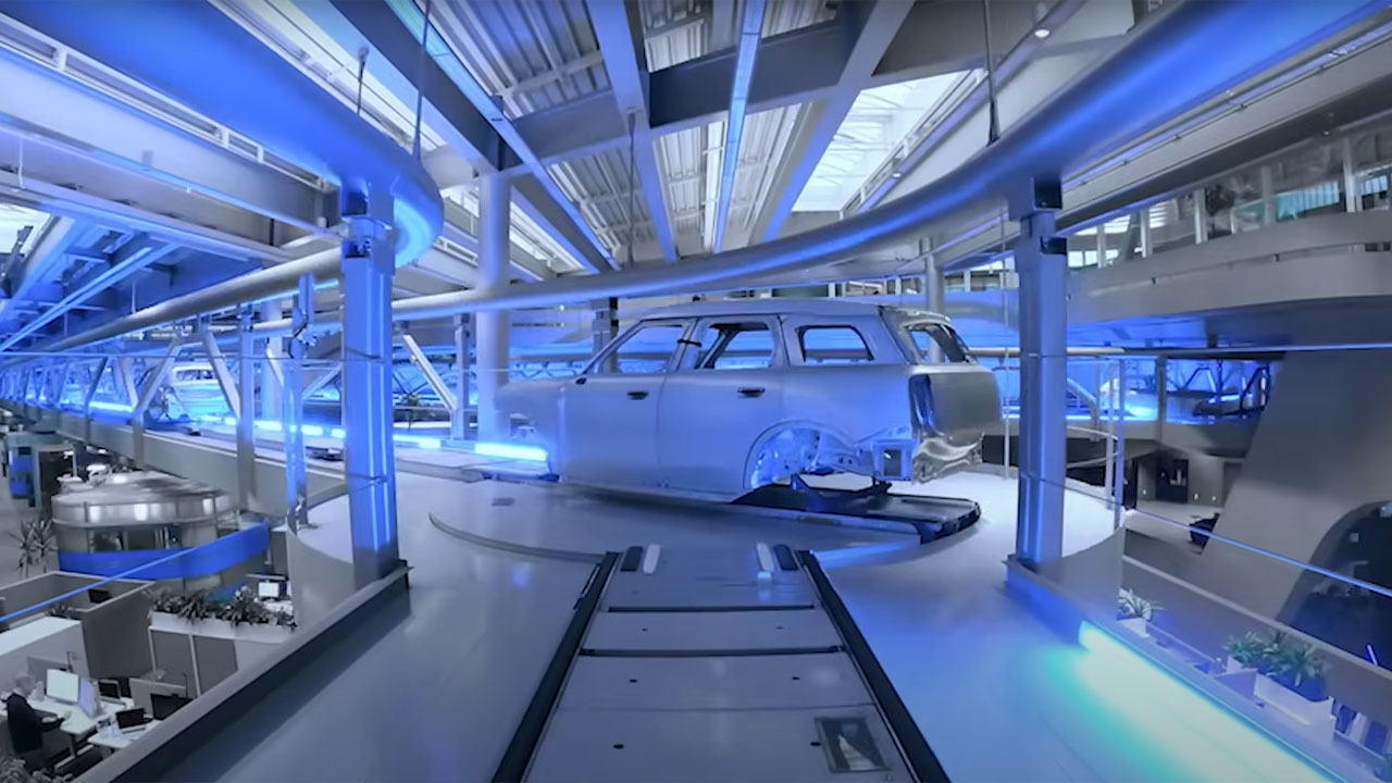 A factory interior featuring blue lights and a car moving along a conveyor belt.