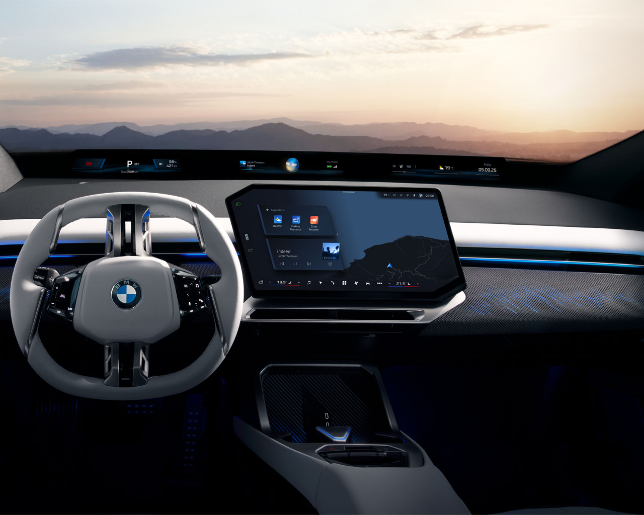 The interior of a BMW iX3 with a modern steering wheel, a large touchscreen, and a landscape in the background.