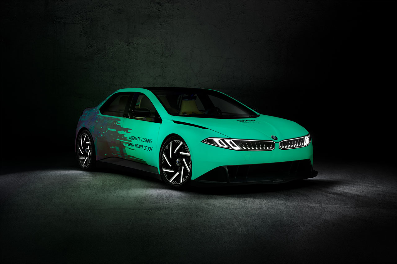 A green BMW Vision Driving Experience in the dark, with just minimal lighting to highlight its form.