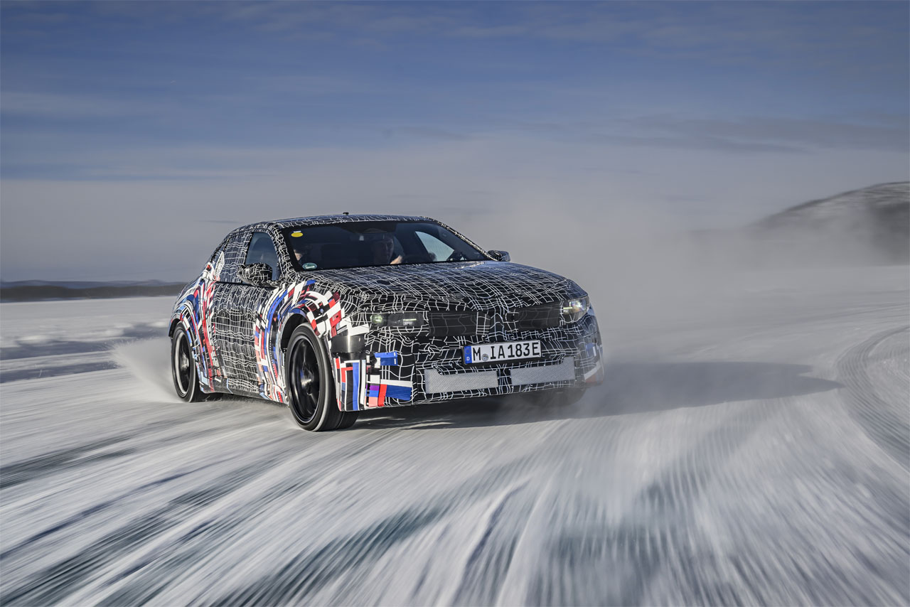 A camouflaged prototype of the latest-generation BMW M drifts across an icy track.