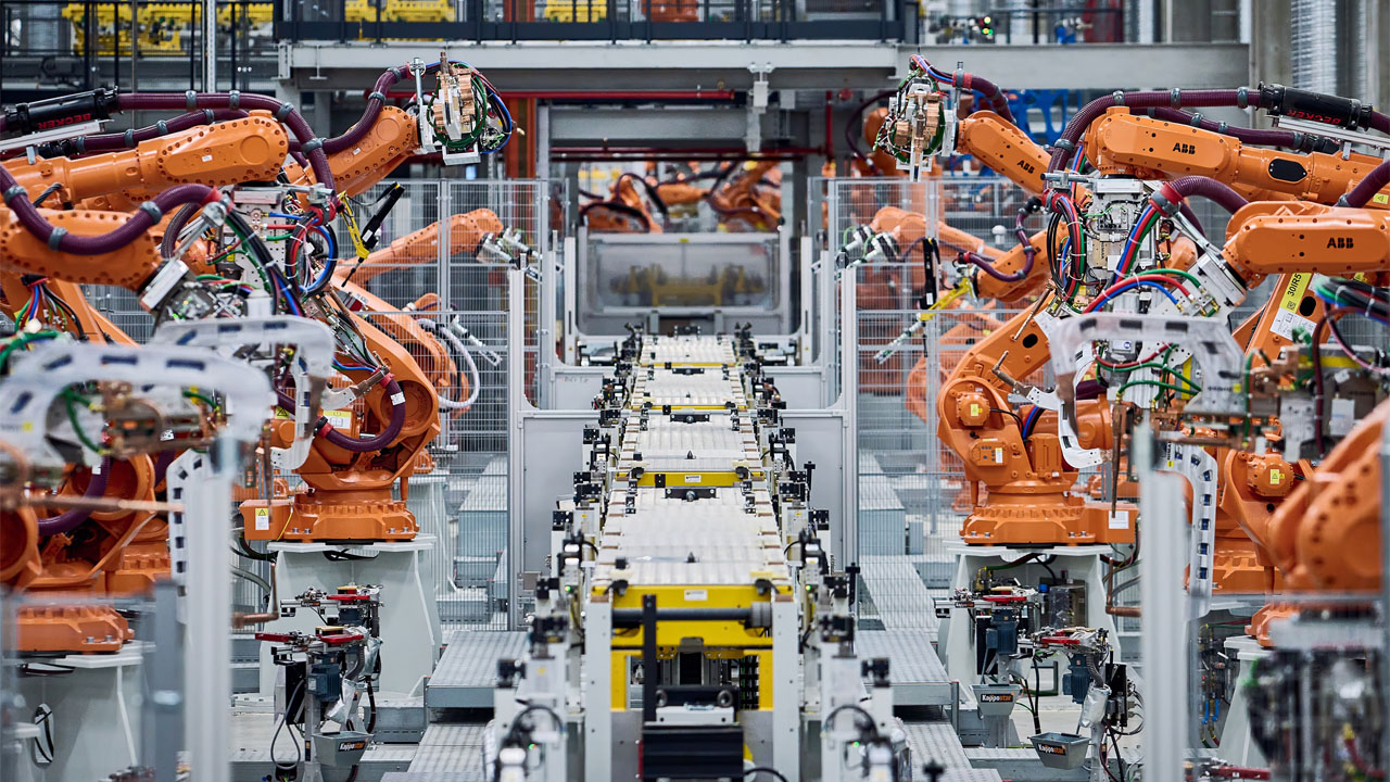 New, highly automated body shop: Orange-and-black robot arms assemble and weld body parts at BMW Group Plant Munich. 