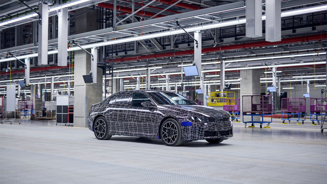 Neue Klasse ramps up: A camouflaged pre-series BMW i3 beside the new production line at BMW Group Plant Munich.