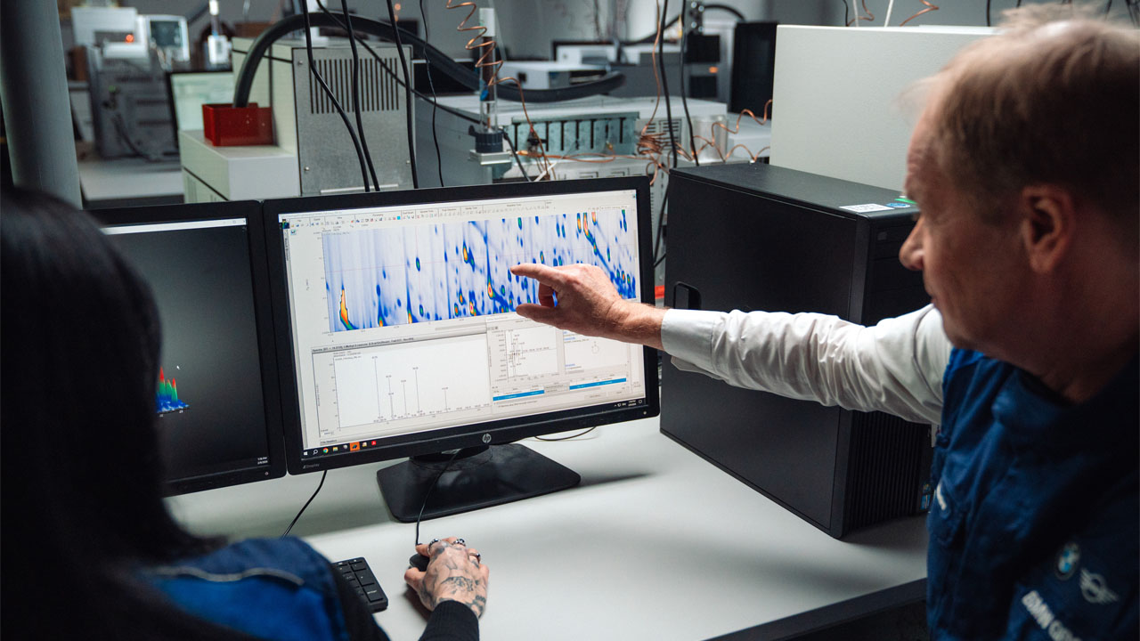 In the BMW Group scent lab, two specialists analyse measurement data displayed on a screen.