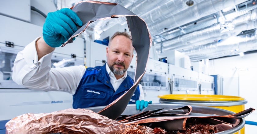 A man in a factory hall lifts copper materials.