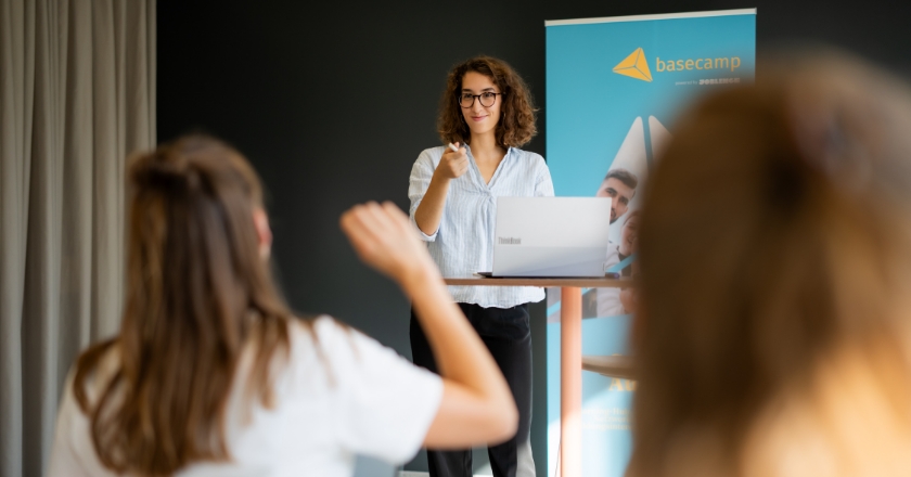 A woman at the lectern calls on a person in the audience.