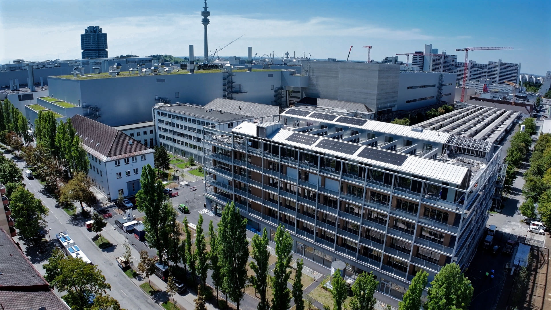 Aerial view of the BMW Group Talent Campus building with roof sections partly equipped with solar panels.
