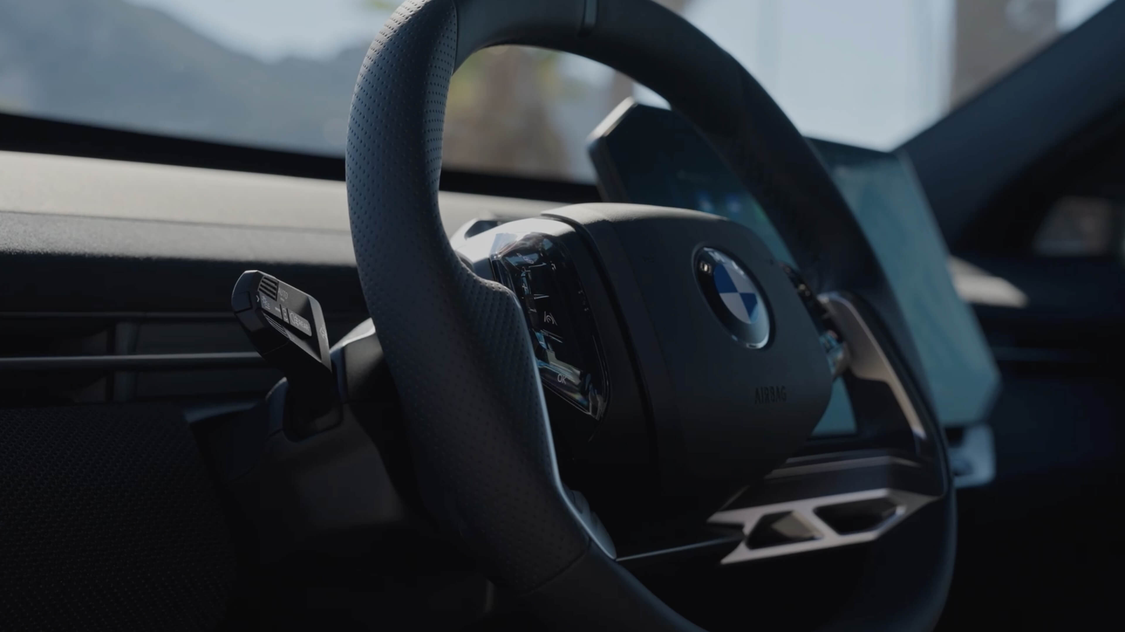 Multifunction steering wheel with integrated controls in the cockpit of a car.