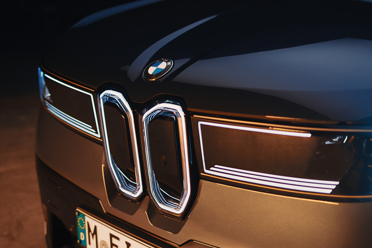 Detail of the illuminated kidney grille and light signatures on the front of a BMW vehicle.