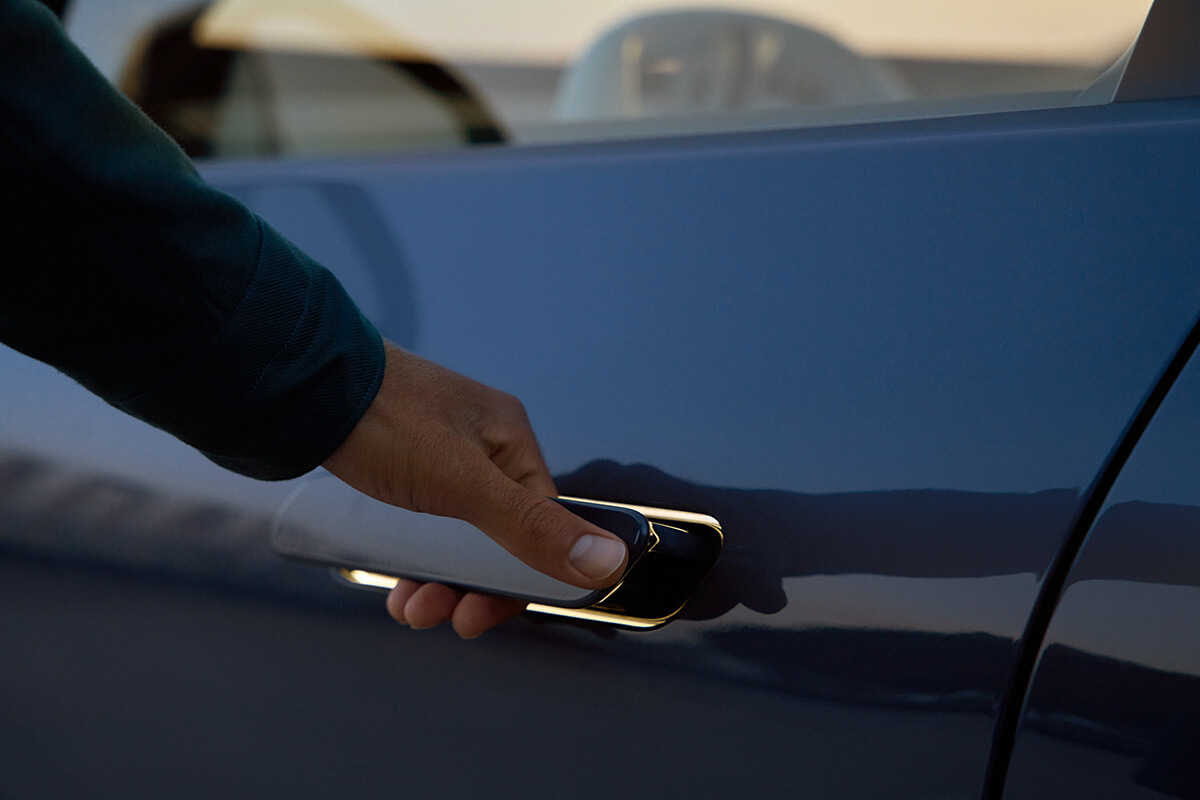 Hand grasping the flush-integrated door handle of a BMW vehicle.