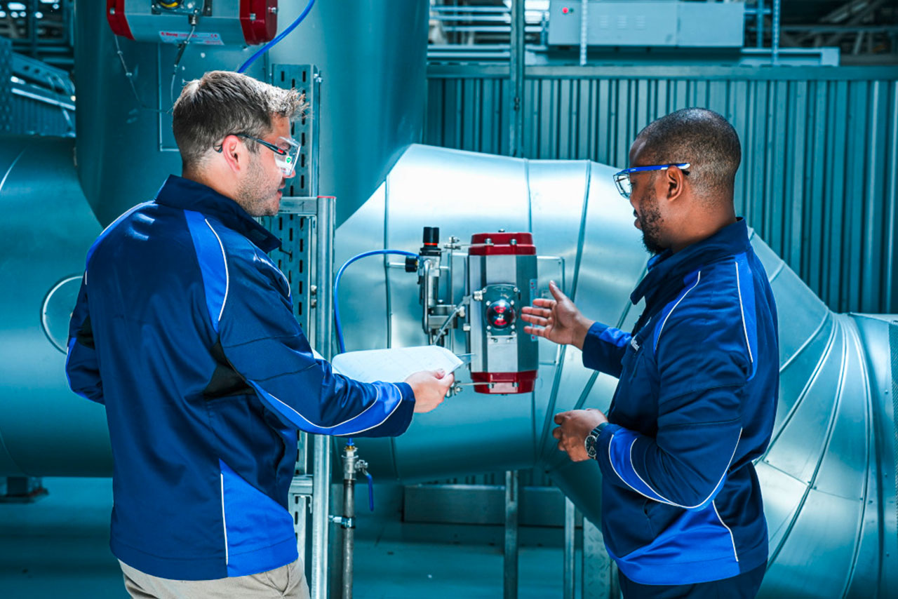 Two employees in the BMW Group paint shop are talking about a machine.