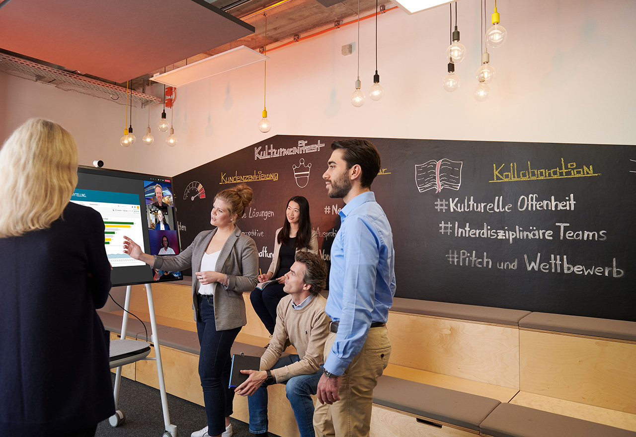BMW employees chat during a meeting in a presentation room.