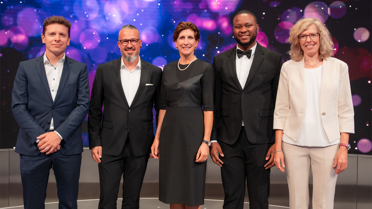 A group of people pose for a photo on a stage.