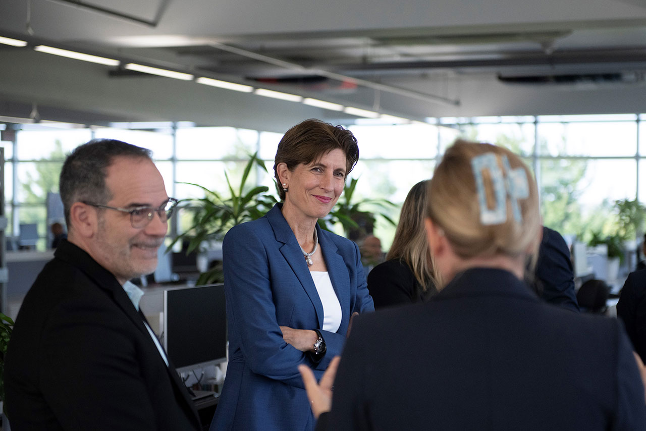 Ilka Horstmeier, member of the Board of Management of BMW AG, wearing a suit, talks to other people in a business setting.