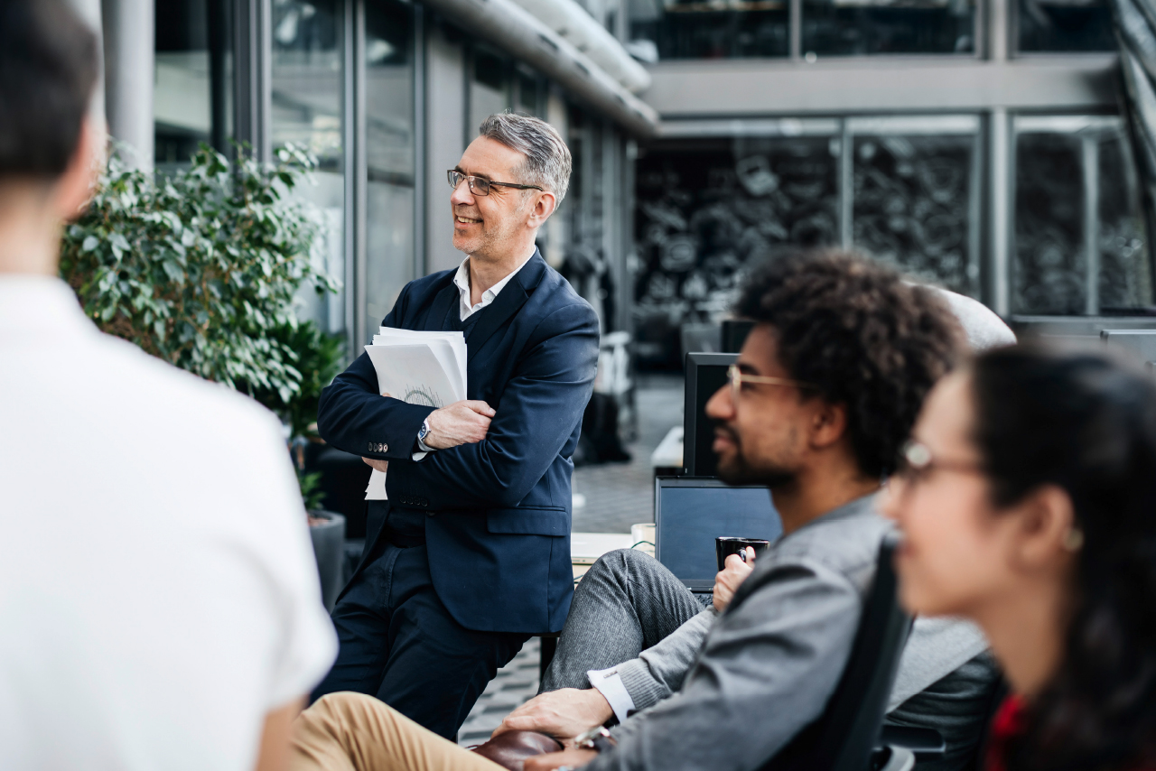 A man in a suit is talking to a group of people.