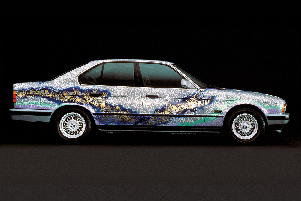 Artistic BMW E30 with unique paint design featuring gold and blue accents.